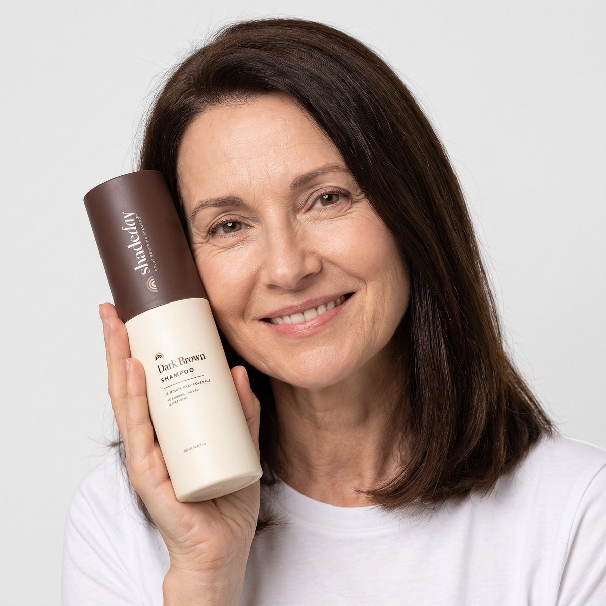 Woman holding the Shadeday tube in Dark Brown